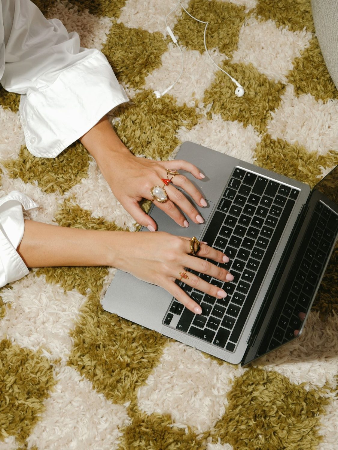 Handen typen op een laptop op een geruit kleed